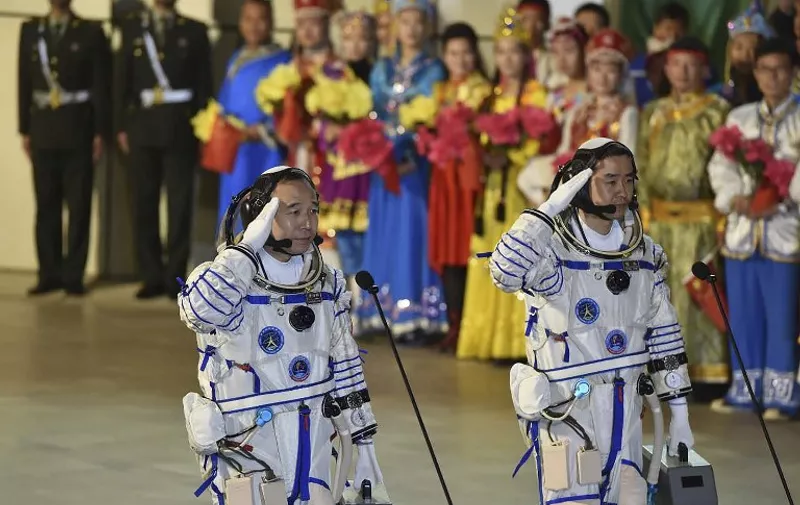 Chinese astronauts Jing Haipeng (L) and Chen Dong salute during the send-off ceremony of the Shenzhou-11 manned space mission at the Jiuquan Satellite Launch Center in Jiuquan, northwestern China's Gansu Province on October 17, 2016. 
China launched two astronauts into space on October 17, official media said, on a mission to its orbiting laboratory as the country works towards setting up its own space station. / AFP PHOTO / STR / China OUT