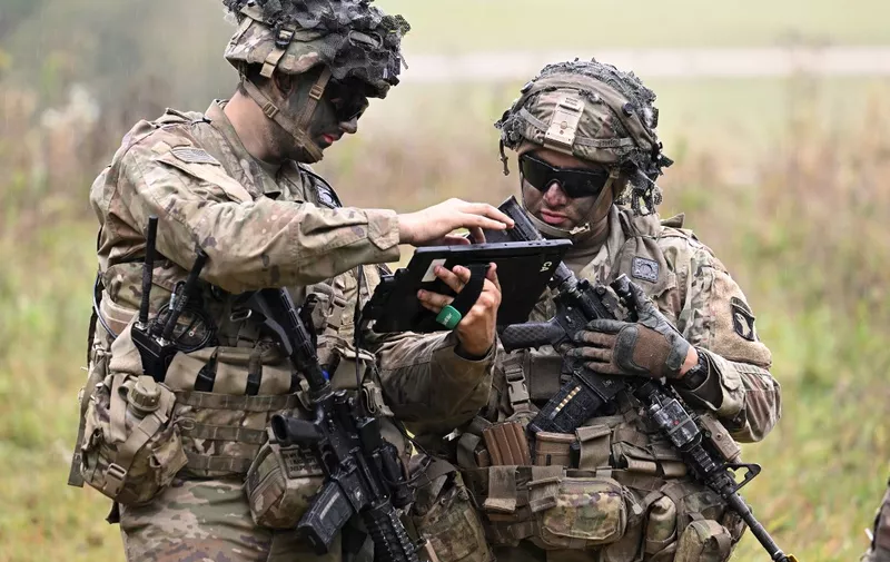US soldiers check a tablet computer during the US army Europe and Africa-directed exercise Combined Resolve 19 at the Hohenfels trainings area, southern Germany, on October 24, 2023. Combined Resolve is a recurring exercise designed to prepare a US brigade combat team in support of NATO deterrence initiatives while also developing and enhancing NATO and key partners interoperability and readiness across specified warfighting functions. (Photo by Christof STACHE / AFP)
