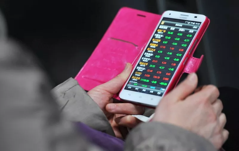 --FILE--A Chinese investor looks at prices of shares (red for price rising and green for price falling) on her smartphone at a stock broekrage house in Fuyang city, east China's Anhui province, 19 January 2015.

China had 649 million Internet users by the end of 2014, with 557 million of those using handsets to go online, said a government report on Tuesday (3 February 2015), as the world's biggest smartphone market continues its shift to mobile. While growth is slowing, China's total Internet population still rose by 31 million in 2014, said the report by the China Internet Network Information Center (CNNIC). Growth in mobile internet users was faster, at 57 million. Riding this wave are some of China's, and the world's, biggest technology companies. These include e-commerce groups Alibaba and JD.com Inc, social networking and video games firm Tencent Holdings Ltd, search giant Baidu Inc and smartphone maker Xiaomi Inc