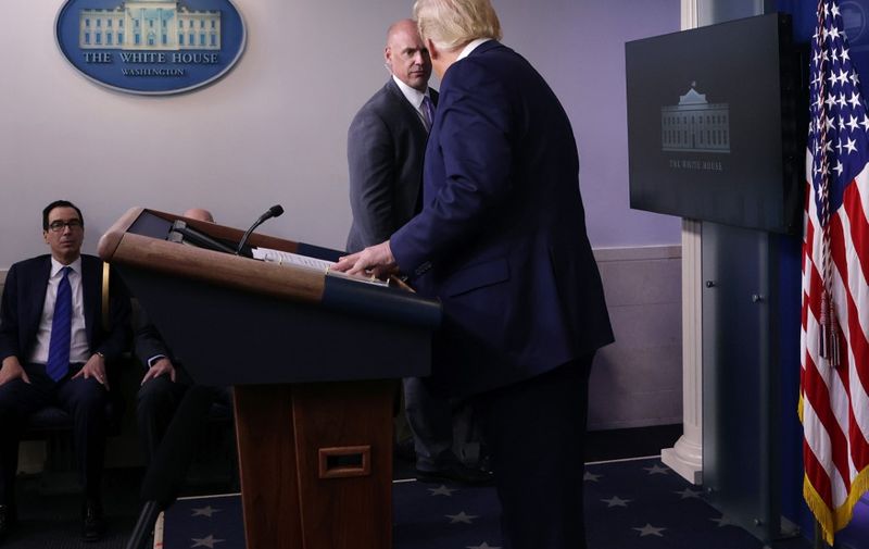 WASHINGTON, DC - AUGUST 10: A U.S. Secret Service agent tells U.S. President Donald Trump to leave the briefing room after shots were reported fired near the White House August 10, 2020 in Washington, DC. Trump briefly stopped his news conference but returned after the all-clear was issued.   Alex Wong/Getty Images/AFP
