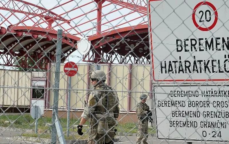 Hungarian soldiers standing guard are pictured from the Croatian side at the Croatian-Hungarian border crossing between the villages of Baranjsko Petrovo Selo, Croatia, and Beremend, Hungary, on September 22, 2015. The Hungary's parliament gave on September 21 the army and police sweeping new powers to keep migrants out as populist Prime Minister Viktor Orban warned that Europe was being "overrun". AFP PHOTO / ELVIS BARUKCIC