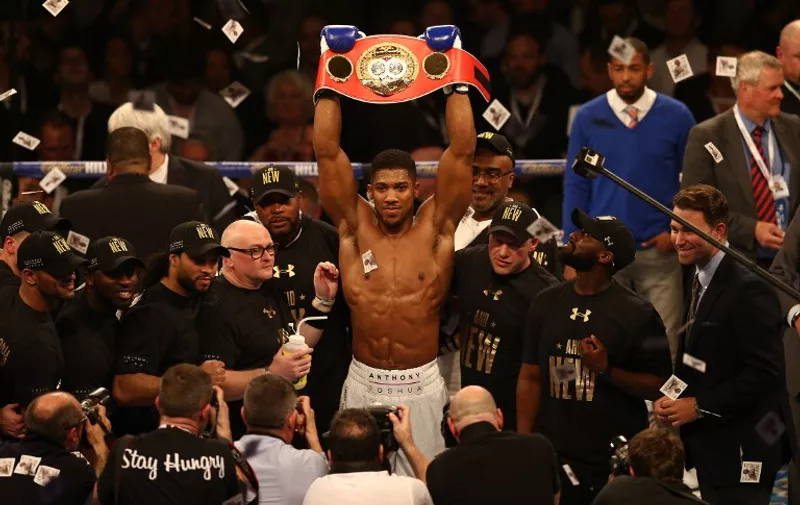 British boxer Anthony Joshua celebrates beating US boxer Charles Martin (not pictured) following their IBF World Heavyweight title boxing match at the O2 arena in London on April 9, 2016.
Britain's Anthony Joshua won the IBF world heavyweight title with a sensational second round knockout of outclassed American rival Charles Martin. Olympic champion Joshua, 26, had Martin on the canvas twice in the second round to record his 16th knockout in all 16 professional fights he has contested. Joshua becomes the sixth British fighter to win a world heavyweight title.  / AFP PHOTO / JUSTIN TALLIS