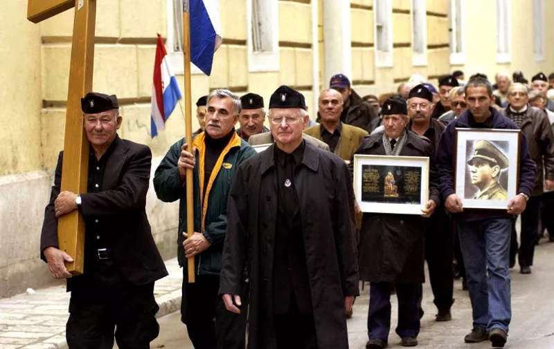 A group of mostly older Croatians, wearing Second World War Ustasha regime uniforms, parade in the Croatian Adriatic resort of Zadar, carrying a portrait of the late Ustasha leader, Ante Pavelic (R), 07 December 2004. Seven Croatians were arrested on charges of carrying hate symbols at a ultra-nationalist rally in honor of soldiers who served the country's Ustasha regime which ruled Croatia during World War II and executed scores of thousands of Serbs, Jews and others in death camps. The Wiesenthal Centre estimates that some 600,000 people -- Serbs, Jews, gypsies and anti-fascists -- were murdered in the most notorious Ustasha camp in northern Croatian town of Jasenovac, while the United States Holocaust Memorial Museum puts the figure at up to 100,000.     AFP PHOTO STRINGER / AFP PHOTO / STRINGER