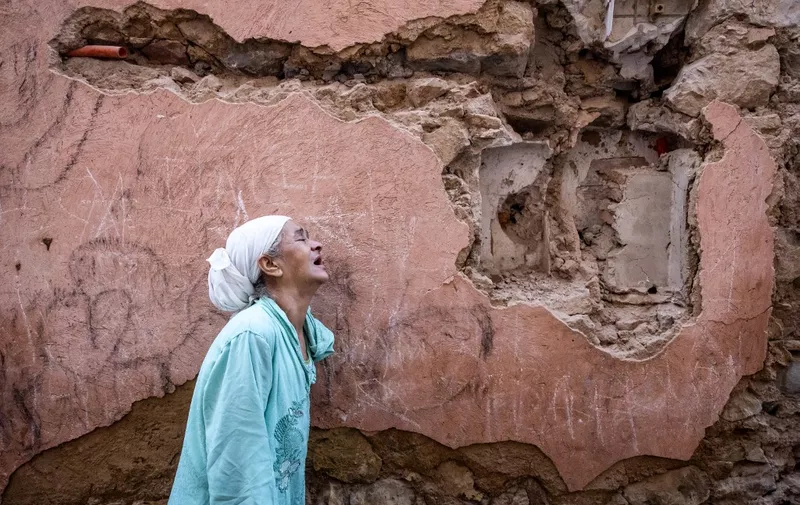 A woman reacts standing infront of her earthquake-damaged house in the old city in Marrakesh on September 9, 2023. A powerful earthquake that shook Morocco late September 8 killed more than 600 people, interior ministry figures showed, sending terrified residents fleeing their homes in the middle of the night. (Photo by FADEL SENNA / AFP)