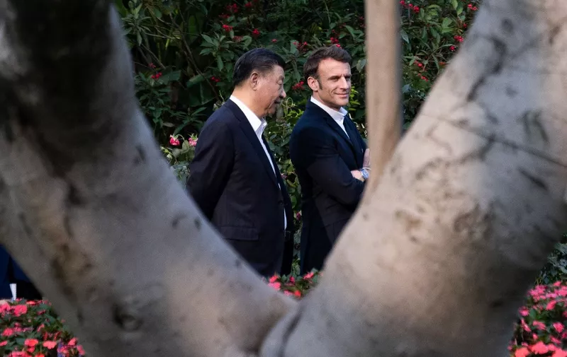 Chinese President Xi Jinping (L) and French President Emmanuel Macron walk in the garden of the residence of the Governor of Guangdong, on April 7, 2023, where Chinese President XI Jinping's father, XI Zhongxun lived. (Photo by Jacques WITT / POOL / AFP)