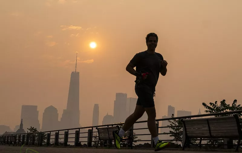 NEW YORK, NEW YORK - JUNE 8: The One World Trade Center and the New York skyline is seen in the background as a man jogs through the Liberty State Park while the smoke from Canada wildfires covers the Manhattan borough on June 8, 2023 in New Jersey.   Eduardo Munoz Alvarez/Getty Images/AFP (Photo by EDUARDO MUNOZ ALVAREZ / GETTY IMAGES NORTH AMERICA / Getty Images via AFP)