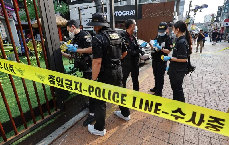 Police officers investigate the scene of an attack near the Sillim subway station in southwest Seoul on July 21, 2023. One person was killed and three more wounded when a man went on a "stabbing rampage" near a subway station in the South Korean capital Seoul on July 21, police told AFP. (Photo by YONHAP / AFP) / - South Korea OUT / NO ARCHIVES -  RESTRICTED TO SUBSCRIPTION USE