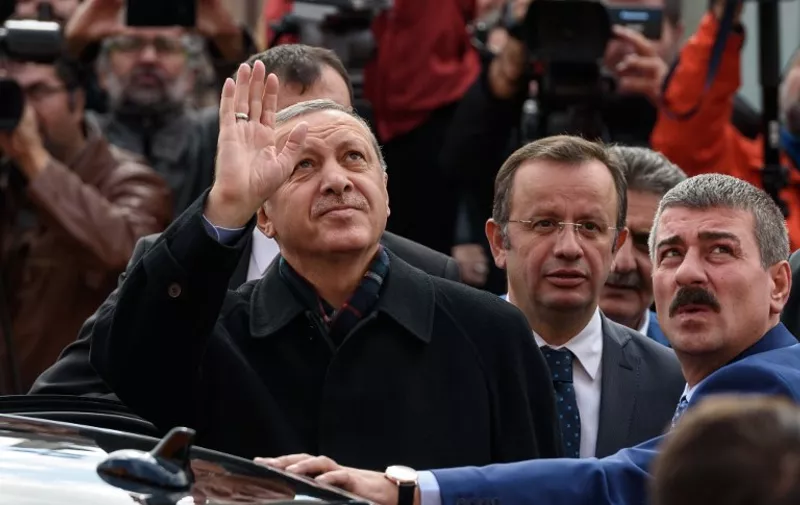 Turkish President Recep Tayyip Erdogan (L) waves to supporters after casting his ballot for Turkey's legislative election at a polling station in Istanbul on November 1, 2015. Turkey voted November 1 in one of its most crucial elections in years, with the country deeply divided in the face of surging Kurdish and Islamic violence and concerns about democracy and the economy. The poll is the second in just five months, called after President Recep Tayyip Erdogan's Justice and Development Party (AKP) was stripped of its parliamentary majority in June for the first time in 13 years and then failed to forge a coalition government. AFP PHOTO / OZAN KOSE