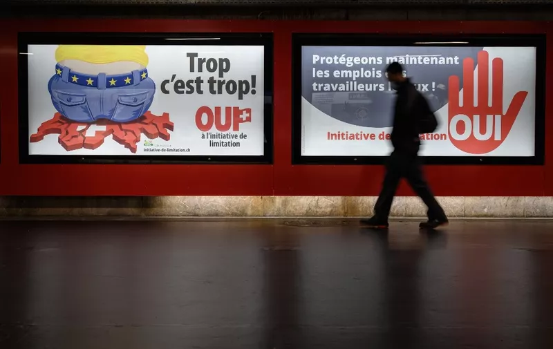 A picture taken on September 1, 2020 in Lausanne shows backlit electoral posters that translates from French as "Too much is too much!" (L) and "Protecting the jobs of local workers now" to advertise a right-wing Swiss Peoples Party (SVP)-backed initiative that voted on September 27, 2020 demanding that the government scrap the freedom of movement agreement with the EU within a year. - A large majority of Swiss voters rejected on September 27, 2020 a bid to dramatically reduce immigration from the European Union, amid fears it would have jeopardised relations with the bloc, projections showed. (Photo by Fabrice COFFRINI / AFP)