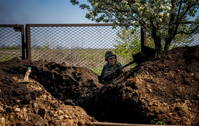 A Ukrainian serviceman of the State Border Guard Service digs a trench in Chasiv Yar near the frontline city of Bakhmut, Donetsk region on May 3, 2023, amid the Russian invasion of Ukraine. (Photo by Dimitar DILKOFF / AFP)