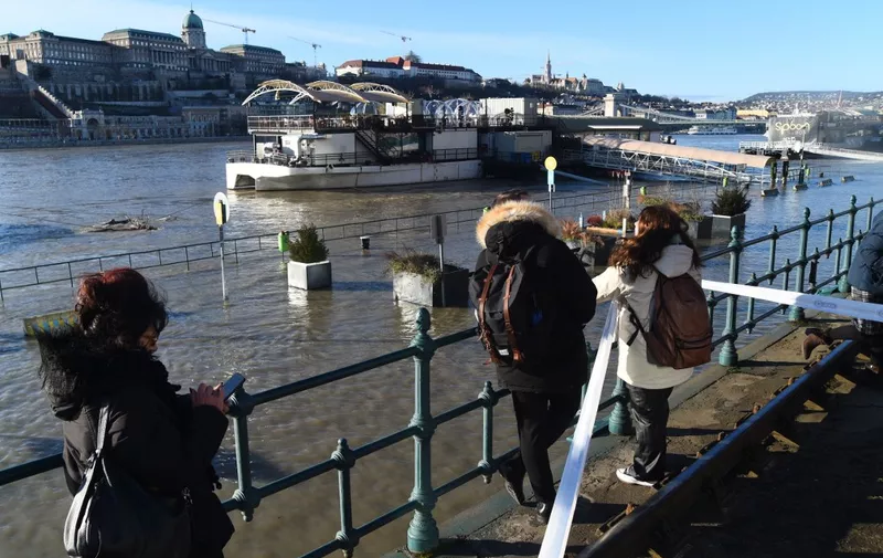People are looking at the embankment of the Danube as a wave of floods is expected on the river, in Budapest, Hungary, on December 28, 2023.  (Photo by Balint Szentgallay/NurPhoto) (Photo by Balint Szentgallay / NurPhoto / NurPhoto via AFP)