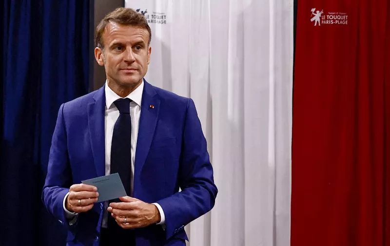 France's President Emmanuel Macron leaves the polling booth prior to cast his vote in the first round of parliamentary elections at a polling station in Le Touquet, northern France on June 30, 2024. A divided France is voting in high-stakes parliamentary elections that could see the anti-immigrant and eurosceptic party of Marine Le Pen sweep to power in a historic first. The candidates formally ended their frantic campaigns at midnight June 28, with political activity banned until the first round of voting. (Photo by Yara Nardi / POOL / AFP)