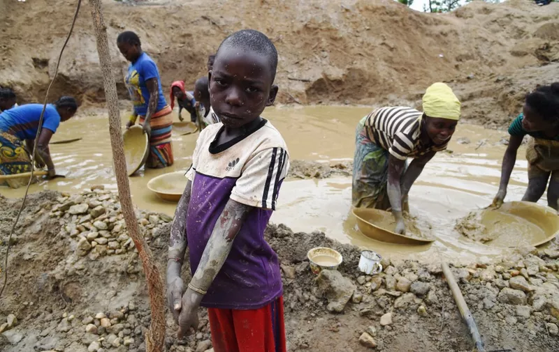 A child gold miner poses on May 5, 2014 while other children look for gold in a traditional mine in the village of Gam, where gold mining in the main business activity of the region. AFP PHOTO / ISSOUF SANOGO (Photo by ISSOUF SANOGO / AFP)