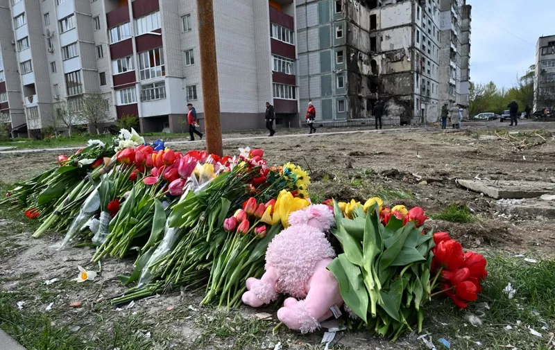 Flowersand dolls are laid in front of a damaged multistory residential building, where a Russian strike killed 23 people, in Uman, Cherkasy region, on April 30, 2023. - A Russian strike on a block of flats in the central Ukrainian city of Uman killed 23 people, including a baby boy on April 28, 2023. (Photo by Genya SAVILOV / AFP)