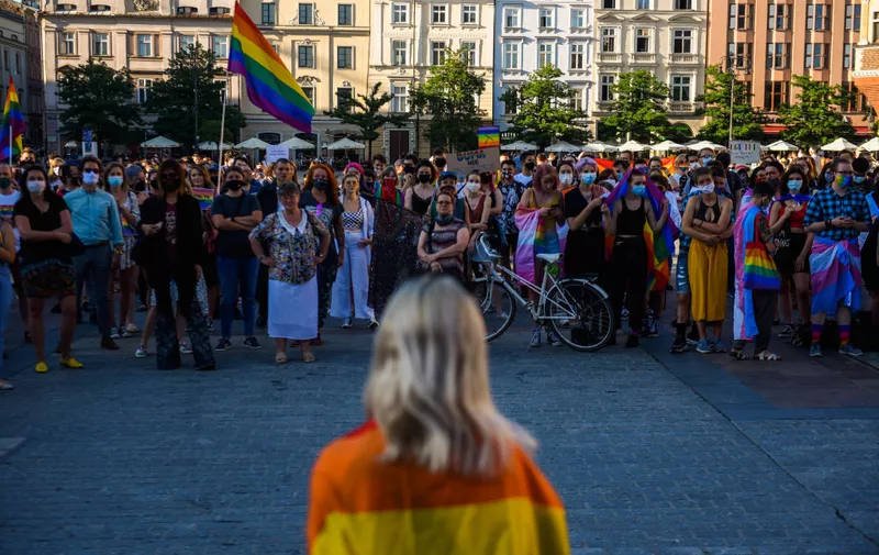KRAKOW, POLAND - JULY 10: A woman wears a protective face mask and a rainbow flag as she gives a speech during a protest against descrimination of the LGBT community two days before the Presidential elections runoff at Krakow's UNESCO listed Main Square on July 10, 2020 in Krakow, Poland. As the country heads into the July 12 presidential runoff election, the current President Andzrej Duda, backed by the conservative right wing Law and Justice Party proposed a constitutional amendment banning same-sex couples from adopting children. (Photo by Omar Marques/Getty Images)