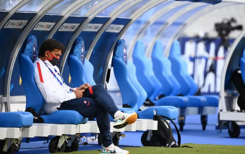 Croatia's head coach Zlatko Dalic watches his phone as he sits on the bench during the UEFA Nations League Group C football match between France and Croatia at the Stade de France in Saint-Denis, near Paris on September 8, 2020. (Photo by FRANCK FIFE / AFP)