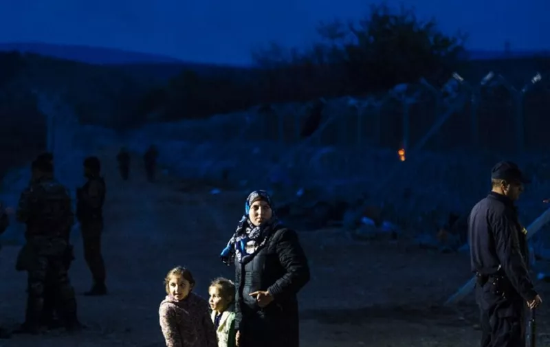 A woman and her children await permission to be registered at the camp after they cross the Greek-Macedonian border near the town of Gevgelija on March 3, 2016. 
 On March 3, EU President Donald Tusk issued a blunt warning to economic migrants not to come to Europe, and chastised EU countries which have taken unilateral action to tackle the crisis. Athens said it now had nearly 32,000 migrants on its territory, after Austria and Balkan states began restricting entries, creating a bottleneck in Greece.   / AFP PHOTO / DIMITAR DILKOFF