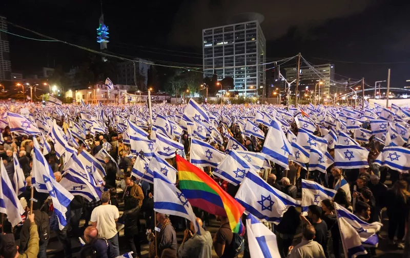 Demonstrators wave flags during a rally to protest the Israeli government's judicial overhaul bill in Tel Aviv, on April 29, 2023. (Photo by JACK GUEZ / AFP)