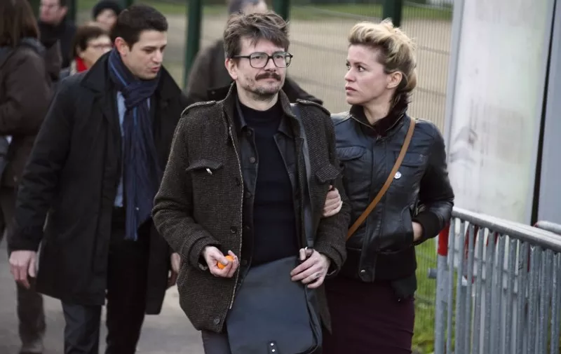 French cartoonist Renald Luzier, aka Luz (C), arrives with his companion Camille Emmanuelle  for the funeral of French cartoonist and Charlie Hebdo editor Stephane "Charb" Charbonnier, on January 16, 2015 in Pontoise, outside Paris. Twelve people were killed, including cartoonists Charb, Wolinski, Cabu and Tignous and deputy chief editor Bernard Maris when gunmen armed with Kalashnikovs and a rocket-launcher opened fire in the Paris offices of Charlie Hebdo on January 7. AFP PHOTO / DOMINIQUE FAGET