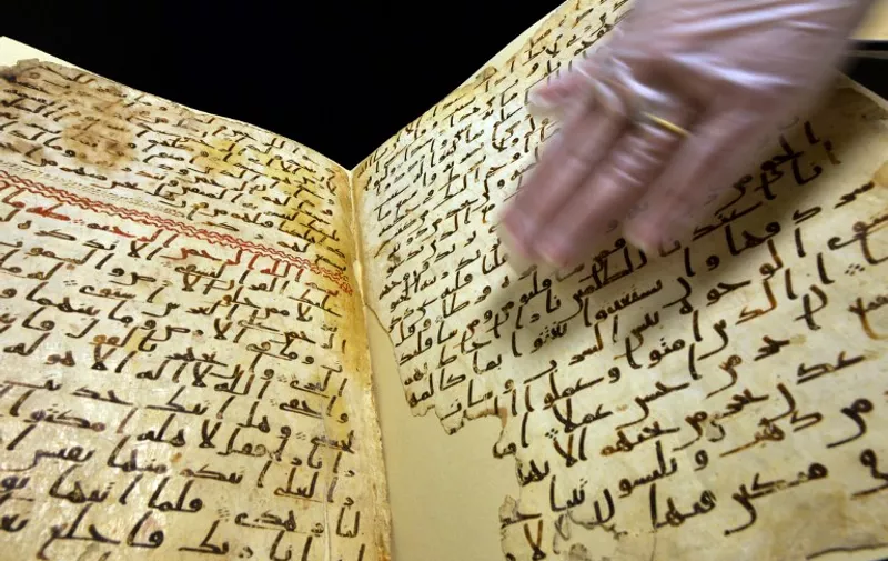 Marie Sviergula, conservator of the University of Birmingham holds a Koran mauscript in Birmingham England on July 22, 2015. A Koran manuscript has been carbon dated to close to the time of the Prophet Mohammed, making it one of the oldest in the world, a British university said today. The two leaves of parchment, filled with "surprisingly legible" text from Islam's holy book, have been dated to around the early seventh century, the University said.  
AFP PHOTO / PAUL ELLIS