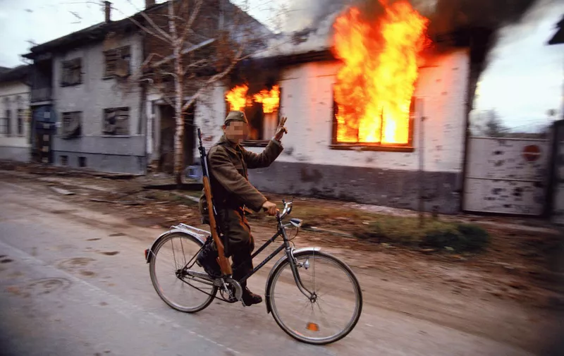 Soldiers and Paramilitaries - A Serbian soldier cycles by a burning house on the destroyed streets of the Croatian city of Vukovar, Nov. 24, 1991. The city was completely destroyed after three months of bombing by Serbian forces., Image: 116177603, License: Rights-managed, Restrictions: Content available for editorial use, pre-approval required for all other uses.
This content not available to be downloaded through Quick Pic
Not available for license and invoicing to customers located in the Czech Republic.
Not available for license and invoicing to customers located in the Netherlands.
Not available for license and invoicing to customers located in India.
Not available for license and invoicing to customers located in Finland.
Not available for license and invoicing to customers located in Italy., Model Release: no, Credit line: Profimedia, Corbis VII