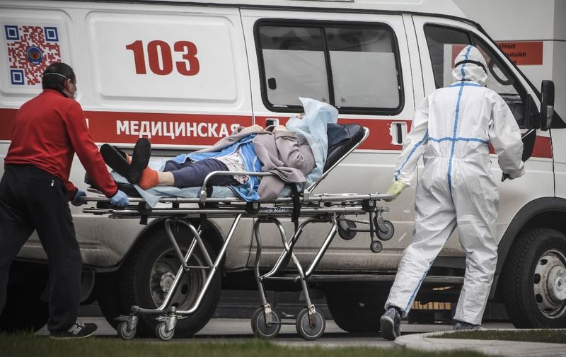Medical workers transport a woman into a hospital where patients infected with the COVID-19 novel coronavirus are being treated in the settlement of Kommunarka outside Moscow on April 27, 2020. (Photo by Alexander NEMENOV / AFP)