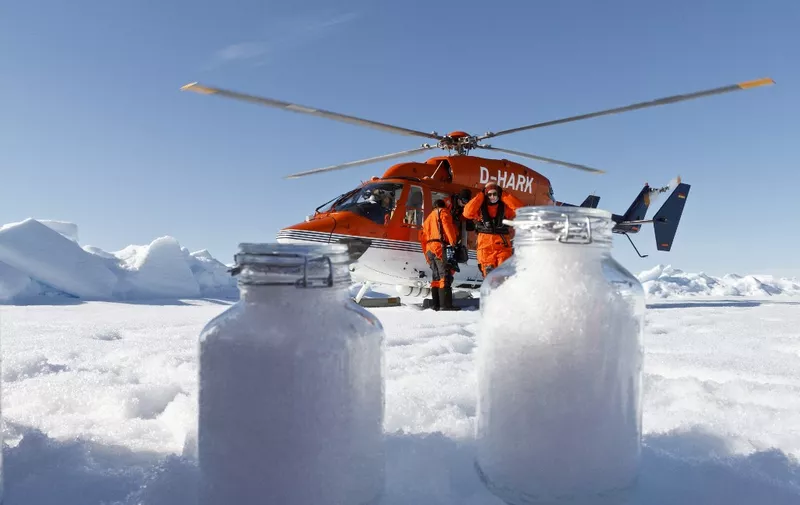 In this August 4, 2017, image courtesy of the Alfred Wegener Institute, scientists from the  institute use the helicopter from the icebreaker research vessel Polarstern to collect snow samples in the Arctic. - Minute microplastic particles have been detected in the Arctic and the Alps, carried by the wind and later washed out in the snow, according to a study that called for urgent research to assess the health risks of inhalation. Every year, several million tonnes of plastic litter course through rivers and out to the oceans, where they are gradually broken down into smaller fragments through the motion of waves and the ultraviolet light of the Sun. The new study, conducted by scientists at Germany's Alfred Wegener Institute and Switzerland's Institute for Snow and Avalanche Research, found that microplastic particles can be transported tremendous distances through the atmosphere. (Photo by Kajetan Deja / Alfred-Wegener-Institut, Helmhol / AFP) / RESTRICTED TO EDITORIAL USE - MANDATORY CREDIT "AFP PHOTO / Kajetan Deja / Alfred-Wegener-Institut, Helmhol" - NO MARKETING NO ADVERTISING CAMPAIGNS - DISTRIBUTED AS A SERVICE TO CLIENTS
