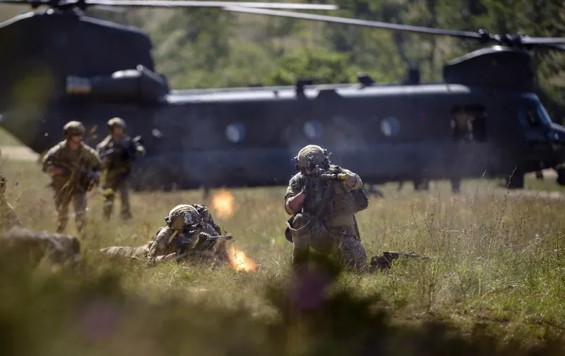 American special forces soldiers fire as they advance during the "Swift Response" airborne training exercise in Hohenfels, southern Germany on August 26, 2015. Some 5,000 soldiers from 11 NATO nations participate in simultaneous multinational airborne operations across Germany, Italy, Bulgaria and Romania. AFP PHOTO / PHILIPP GUELLAND