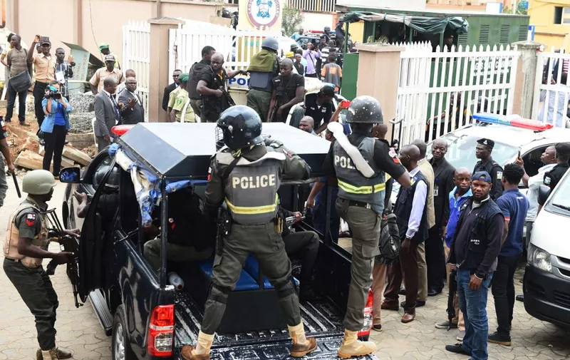 Nigerian ant-riot police officers escort a suspected kidnap kingpin to prison after he was arraigned at the Lagos State High Court on August 30, 2017. - Suspected Nigerian kidnap kingpin Chukwudubem Onwuamadike, known as "Evans", has pleaded guilty to the kidnapping charges against him after being arraigned along with five other possible accomplices. (Photo by PIUS UTOMI EKPEI / AFP)