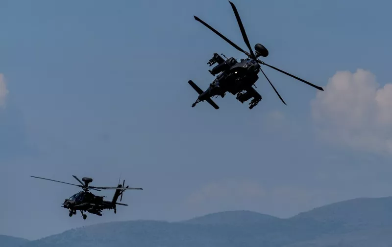 US AH-64 Apache helicopters fly during the Swift Response 22 military exercise at the Krivolak Military Training Center in Negotino, in the centre of North Macedonia, on May 12, 2022. - The excercise, which involves approximately 4,600 soldiers from North Macedonia, Albania, Montenegro, Greece, Italy, as well as France, the UK and the US, is meant to show that NATO forces can be deployed around the world and fully cooperate. (Photo by Robert ATANASOVSKI / AFP)