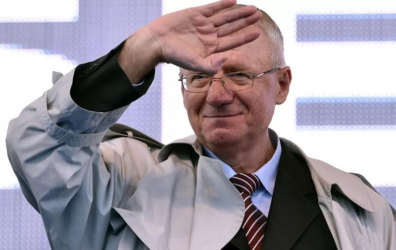 Serbian nationalist politician Vojislav Seselj waves to his supporters during an anti-government rally in Belgrade on November 15, 2014. Seselj is spearheading an anti-government rally but as he fights cancer and awaits judgement on war crimes charges, he is as beleaguered as his once formidable party.  / 