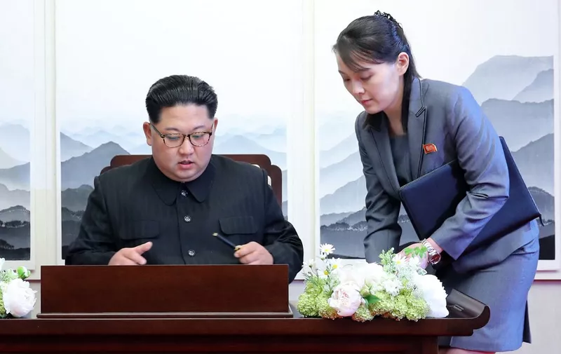 North Korea's leader Kim Jong Un (L) signs the guest book next to his sister Kim Yo Jong (R) during the Inter-Korean summit with South Korea's President Moon Jae-in at the Peace House building on the southern side of the truce village of Panmunjom on April 27, 2018. North Korean leader Kim Jong Un and the South's President Moon Jae-in sat down to a historic summit on April 27 after shaking hands over the Military Demarcation Line that divides their countries in a gesture laden with symbolism. (Photo by Korea Summit Press Pool / Korea Summit Press Pool / AFP)