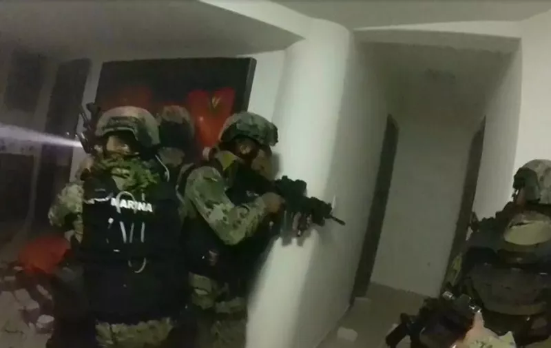 Screen grab from a handout video taken on January 8, 2016 and released by the Mexican Navy showing marines assaulting a house during the operation to recapture Mexico's most wanted drug kingpin, Joaquin "El Chapo Guzman" Guzman in Los Mochis, Mexico. Mexico has begun the process of extraditing Guzman to the United States, where he faces drug-trafficking charges, but that could take "a year or longer" because of legal challenges, said the head of Mexico's extradition office, Manuel Merino. AFP PHOTO/MARINA DE MEXICO  RESTRICTED TO EDITORIAL USE - MANDATORY CREDIT "AFP PHOTO/MARINA DE MEXICO " - NO MARKETING NO ADVERTISING CAMPAIGNS - DISTRIBUTED AS A SERVICE TO CLIENTS / AFP / MEXICAN NAVY / HO