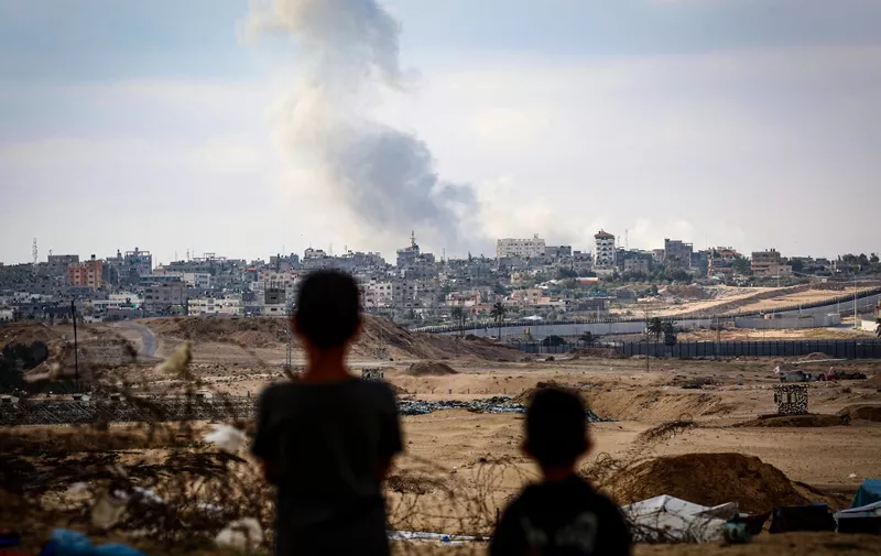 Boys watch smoke billowing during Israeli strikes east of Rafah in the southern Gaza Strip on May 13, 2024, amid the ongoing conflict between Israel and the Palestinian militant group Hamas. (Photo by AFP)