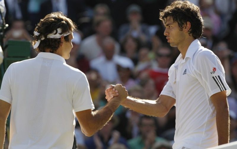 Switzerland's Roger Federer (L) shakes hands with his Croatian opponent Mario Ancic after winning their quarter-final tennis match of the 2008 Wimbledon championships at The All England Tennis Club in southwest London, on July 2, 2008. Federer won 6-1, 7-5, 6-4.       AFP PHOTO / Adrian Dennis