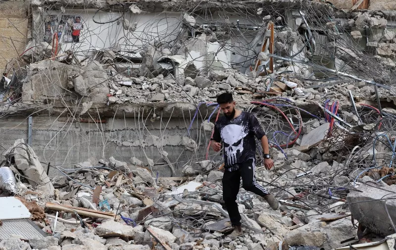 A Palestinian man walks amidst the debris of the house of Rateb Hatab Shukairat, after it was demolished by Israeli bulldozers, in the East Jerusalem neighbourhood of Jabal Mukaber on January 29, 2023. (Photo by AHMAD GHARABLI / AFP)