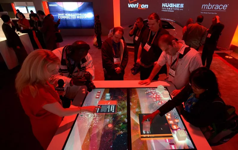 Consumers check informations at Verizon booth  at the 2013 International CES at the Las Vegas Convention Center on January 10, 2013 in Las Vegas, Nevada. CES, the world's largest annual consumer technology trade show, runs from January 8-11 and is expected to feature 3,100 exhibitors showing off their latest products and services to about 150,000 attendees.AFP PHOTO / JOE KLAMAR