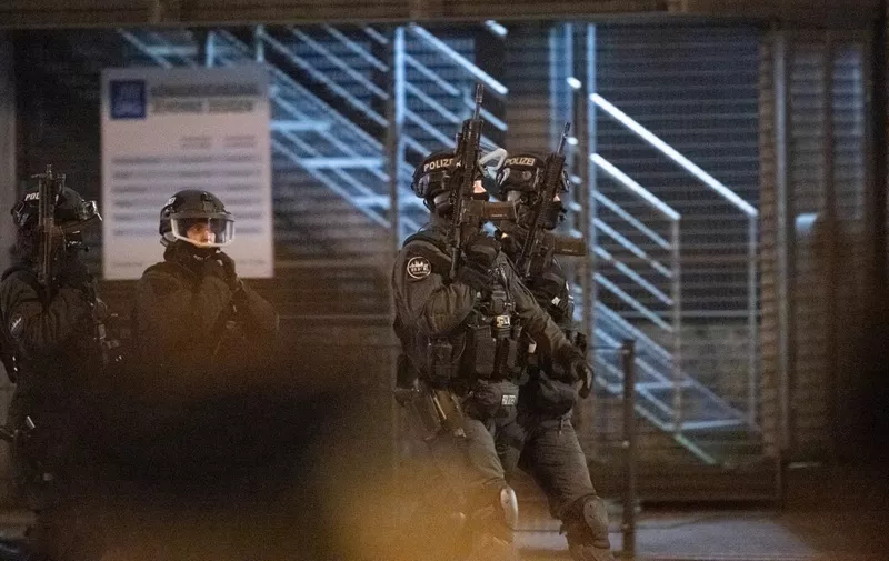 Armed police patrol outside a Jehovah's Witnesses church where several people have been killed in a shooting in Hamburg, northern Germany, on late March 9, 2023. - The gunman is believed to be among several dead found in the building, police said (Photo by Daniel Reinhardt / AFP)