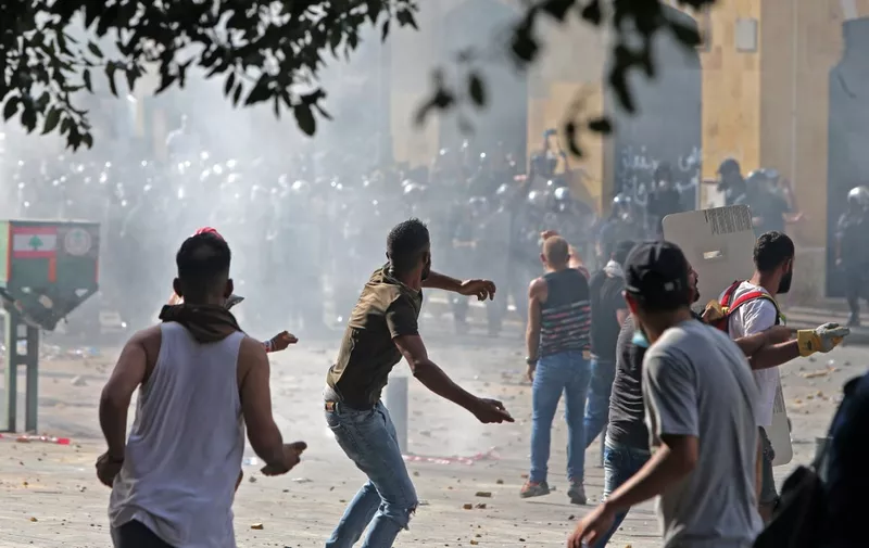 Lebanese protesters hurl rocks towards security forces during clashes in downtown Beirut on August 8, 2020, following a demonstration against a political leadership they blame for a monster explosion that killed more than 150 people and disfigured the capital Beirut. (Photo by STR / AFP)