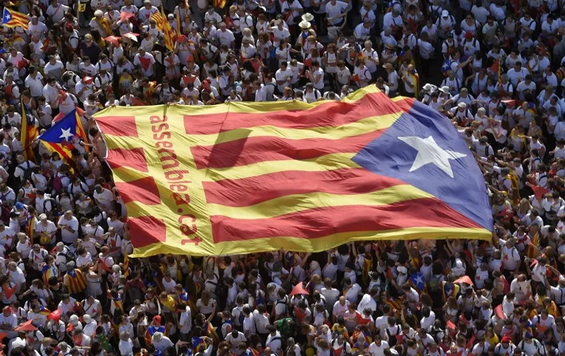 Demonstrators unfold a big "Estelada" (pro independence Catalan flag) during celebrations of Catalonia's National Day (Diada) which recalls the final defeat of local troops by Spanish king Philip V's forces in 1714, in Barcelona on September 11, 2015. Hundreds of thousands of Catalans were set to pour into the streets today demanding independence, ahead of a regional election billed as an indirect vote on breaking away from Spain.    AFP PHOTO/ LLUIS GENE