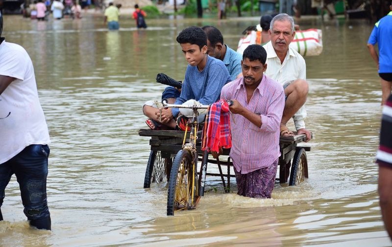 An Indian rickshaw puller transports commuters on a flooded street after a heavy downpour at Baldakhal village in Agartala, the capital of northeastern state of Tripura, on July 14, 2019. (Photo by Arindam DEY / AFP)