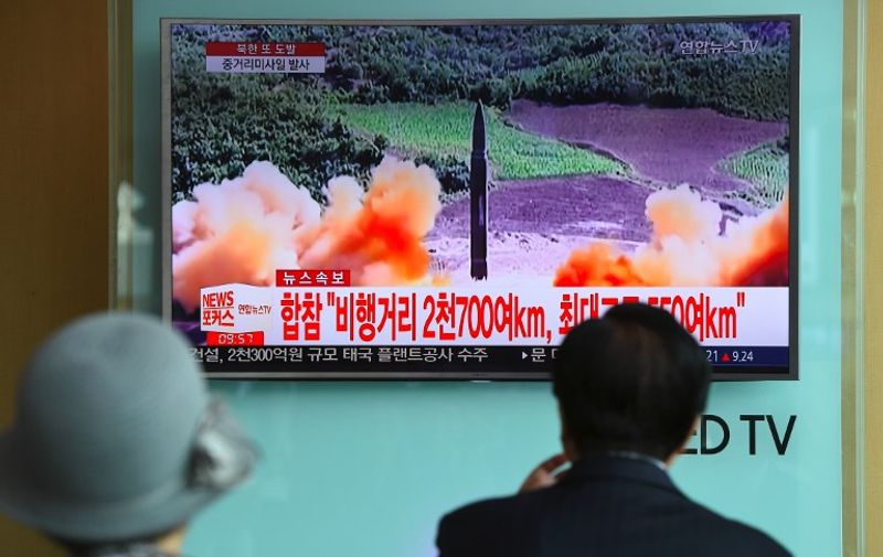 People watch a television news screen showing file footage of a North Korean missile launch, at a railway station in Seoul on August 29, 2017.
Nuclear-armed North Korea fired a ballistic missile over Japan and into the Pacific Ocean on August 29 in a major escalation by Pyongyang amid tensions over its weapons ambitions. / AFP PHOTO / JUNG Yeon-Je