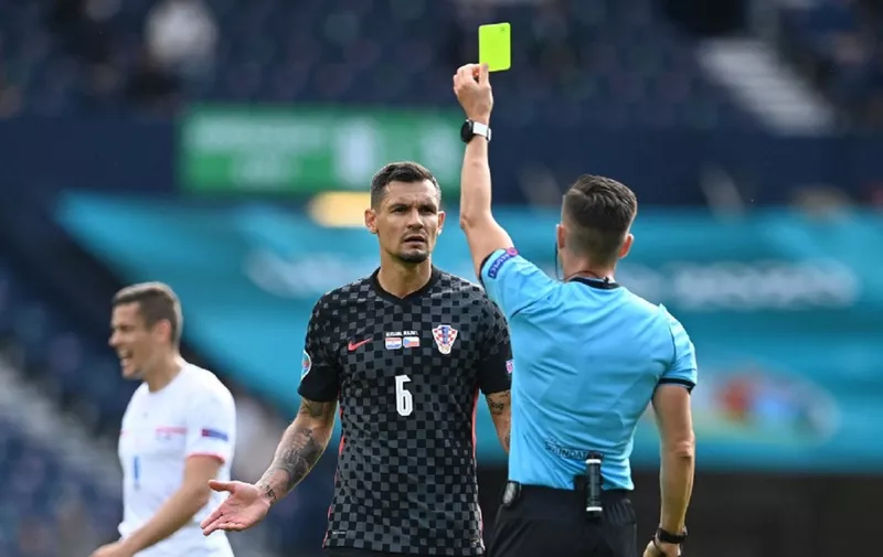 Spanish referee Carlos Del Cerro Grande (R) presents a yellow card to Croatia's defender Dejan Lovren during the UEFA EURO 2020 Group D football match between Croatia and Czech Republic at Hampden Park in Glasgow on June 18, 2021. (Photo by Paul ELLIS / POOL / AFP)