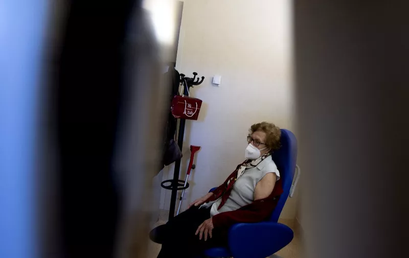 An elderly woman waits to receive a dose of the Pfizer-BioNTech COVID-19 vaccine on February 8, 2021 at the Tor Vergata hospital in Rome, as part of vaccinations for people over 80. - Italy is one of the countries worst affected by the coronavirus pandemic, with over 2.6 million infections and more than 91,000 dead. (Photo by Tiziana FABI / AFP)