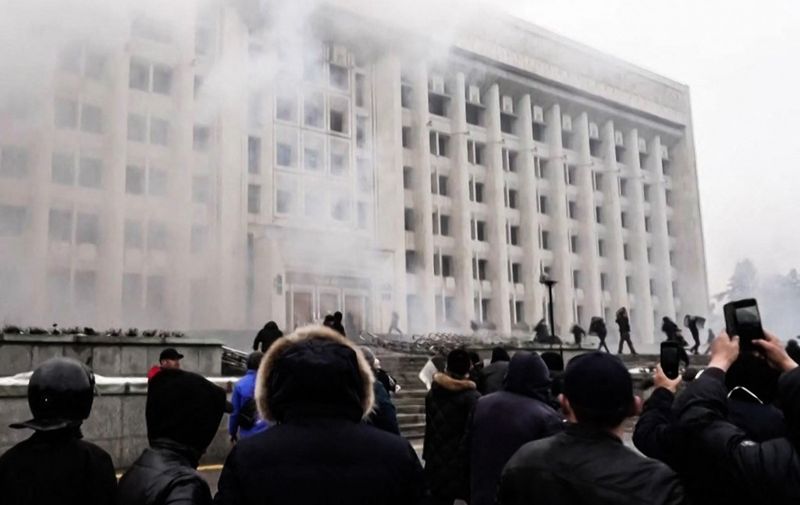 A frame grab taken on January 6, 2022 from an AFPTV video made on January 5, 2022, shows protesters storming in the city hall of Kazakhstan's largest city Almaty as unprecedented unrest in the Central Asian nation spins out of control due to a hike in energy prices. - Protestors took from police officers gears and tear gas during a demonstration in the streets of Almaty that caused the death of twelve security officers and wounded 353 people, media reports said on January 6, 2022. Long seen as one the most stable of the ex-Soviet republics of Central Asia, energy-rich Kazakhstan is facing its biggest crisis in decades after days of protests over rising fuel prices escalated into widespread unrest. (Photo by Alexander PLATONOV / AFPTV / AFP)