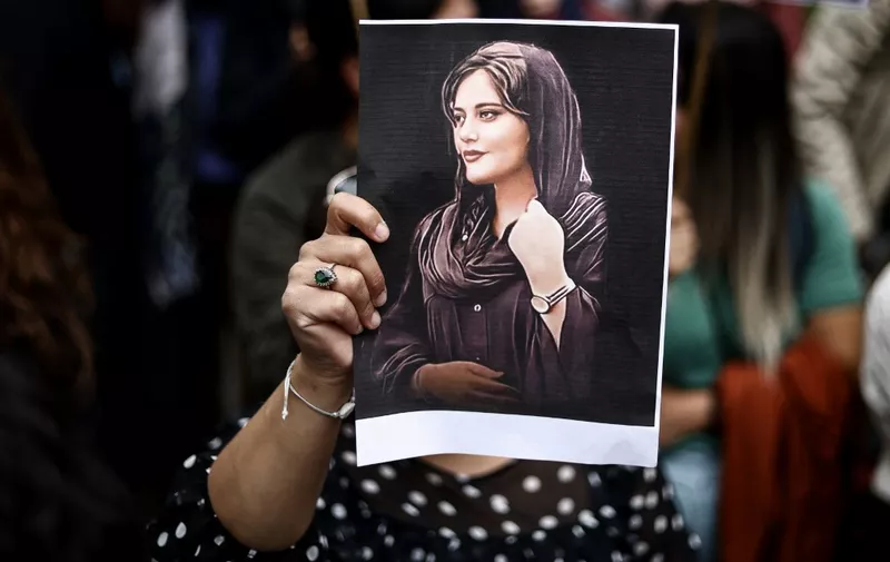 (FILES) A protester holds a portrait of Mahsa Amini during a demonstration in her support in front of the Iranian embassy in Brussels on September 23, 2022, following the death of an Iranian woman after her arrest by the country's morality police in Tehran. A year after the death of Mahsa Amini sparked unrest across Iran, the issue of the hijab remains a sore spot -- but a crippling economic crisis has left many preoccupied with making ends meet. (Photo by Kenzo TRIBOUILLARD / AFP)