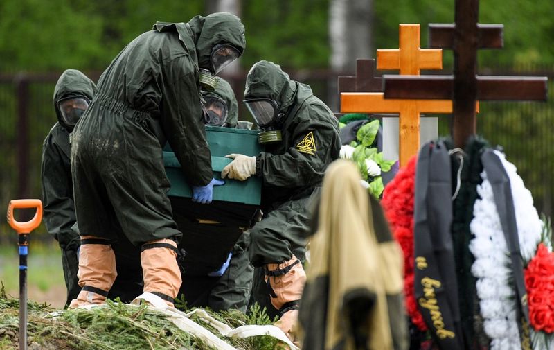 Cemetery workers wearing protective equipment bury a coronavirus victim at a cemetery on the outskirts of Moscow on May 15, 2020. (Photo by Kirill KUDRYAVTSEV / AFP)