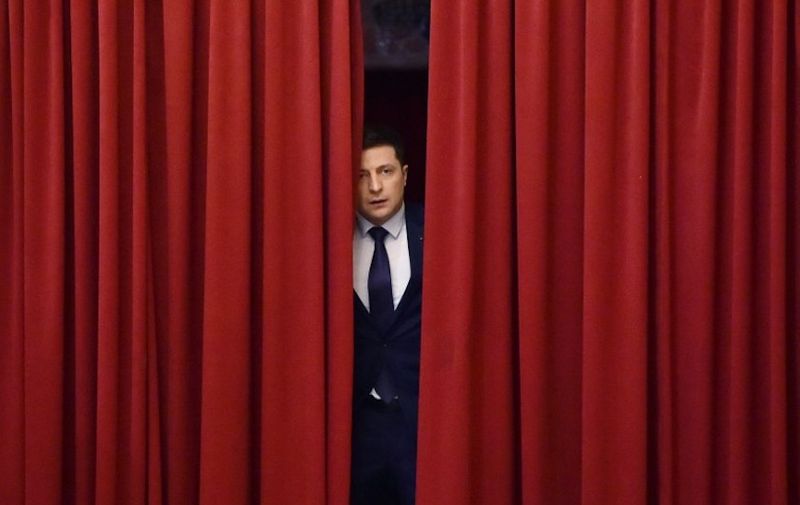 Ukrainian comic actor and the presidential candidate Volodymyr Zelensky enters a hall in Kiev on March 6, 2019, to take part in the shooting of the television series "Servant of the People" where he plays the role of the President of Ukraine. - Anger with the political elite is partly behind the rise of Volodymyr Zelensky, a TV actor with no political experience who is the frontrunner in the upcoming presidential vote.  Zelensky is polling at 25 percent, ahead of Poroshenko on 17 percent and former prime minister Yulia Tymoshenko on 16 percent as of March 4, 2019. (Photo by Sergei SUPINSKY / AFP)