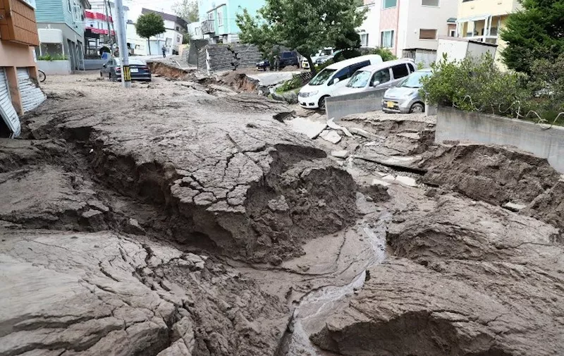 Cars are parked along a road damaged by an earthquake in Sapporo, Hokkaido prefecture on September 6, 2018.
A powerful 6.6-magnitude quake rocked the northern Japanese island of Hokkaido on September 6, triggering landslides, collapsing buildings, and killing at least two people with several dozen missing. / AFP PHOTO / JIJI PRESS / JIJI PRESS / Japan OUT