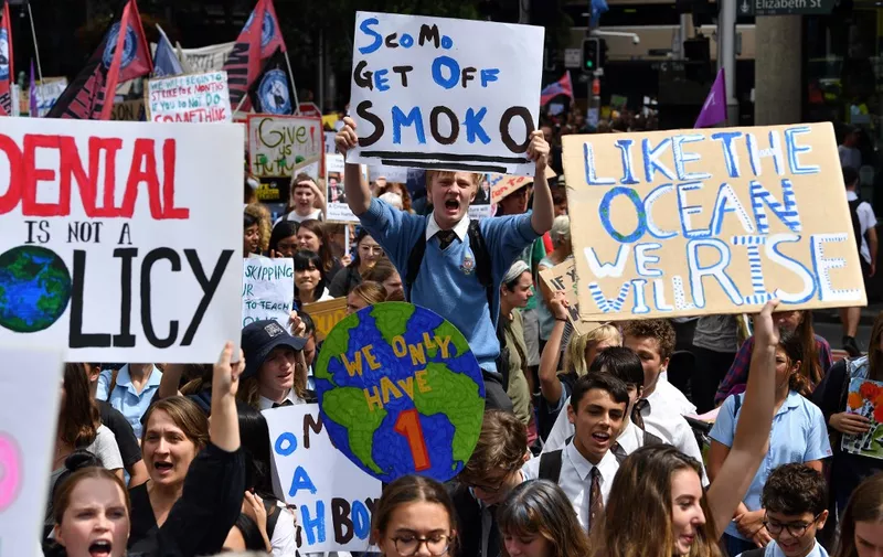 School children shout slogans as they march in a strike and protest by students highlighting inadequate progress to address climate change in Sydney on March 15, 2019. - Thousands of young people marched through cities in Asia kicking off a global day of student protests that aims to spark world leaders into action on climate change. (Photo by Saeed KHAN / AFP)